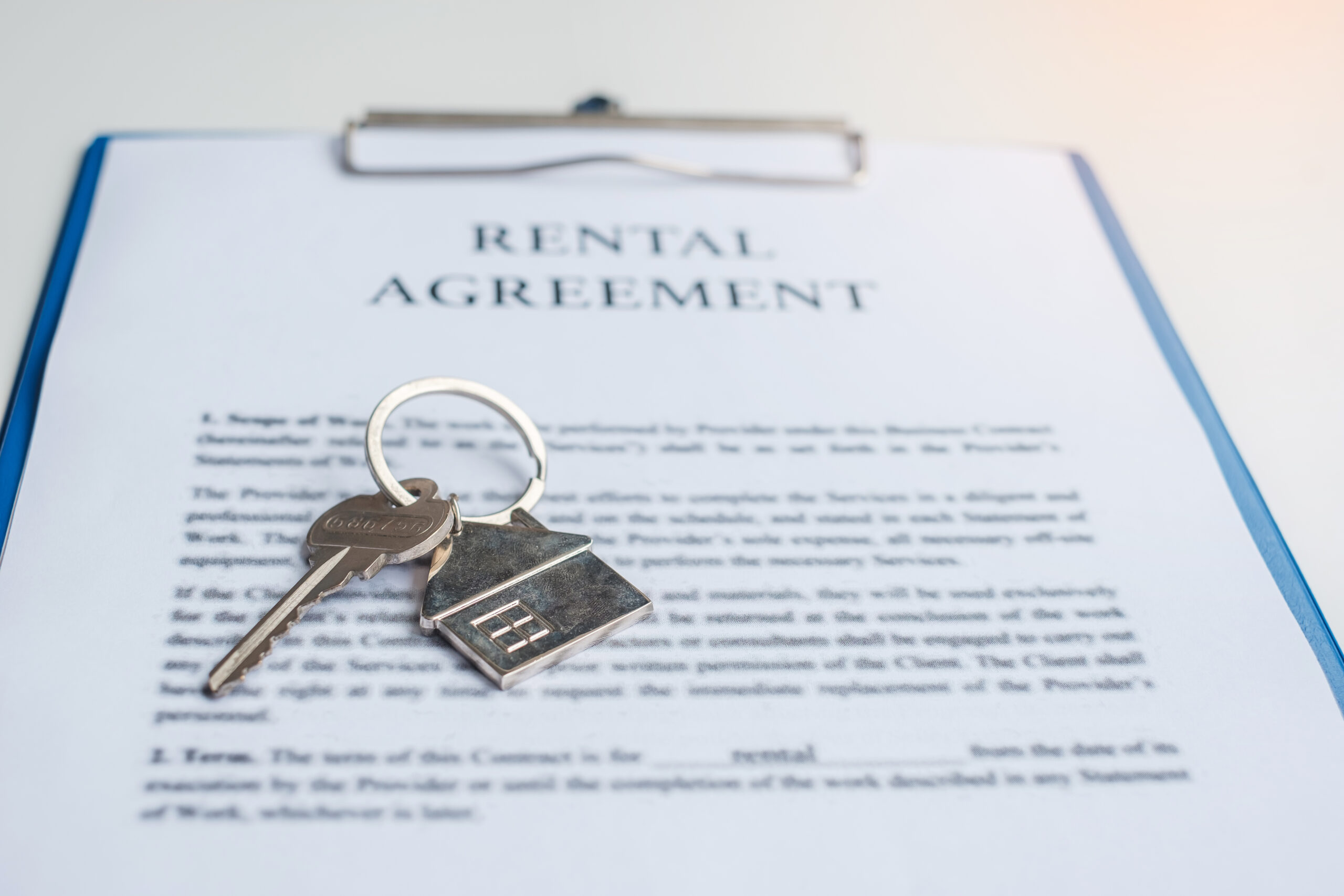 Rental agreement document on a clipboard with house keys placed on top.